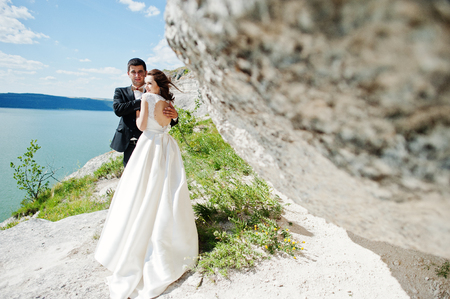 Wedding couple at breathtaking landscape with rock and lake.の写真素材