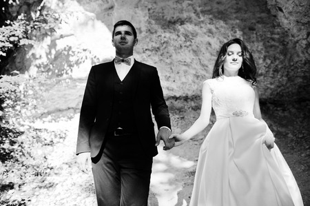 Wedding couple against cave at summer day.の写真素材