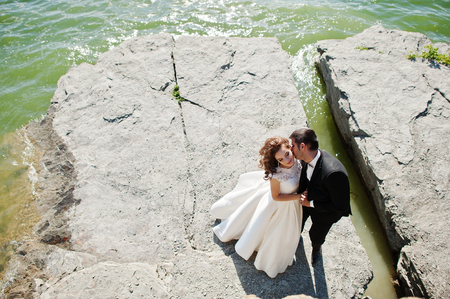 Wedding couple at breathtaking landscape with rock and lake.の写真素材