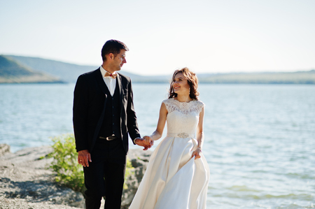 Wedding couple at breathtaking landscape with rock and lake.の写真素材
