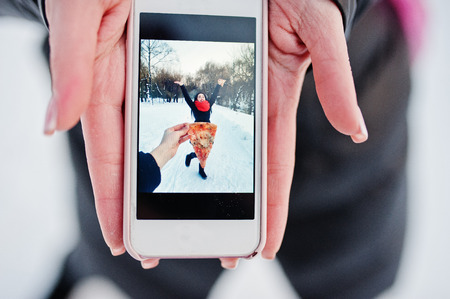 Girl in screen of phone with pizza. Funny concept.