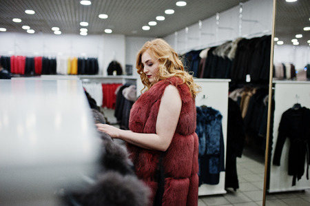 Elegance blonde girl in fur coat at the store of fur coats and leather jackets. の写真素材