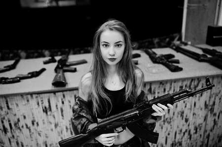 Girl with machine gun at hands on shooting range.の写真素材
