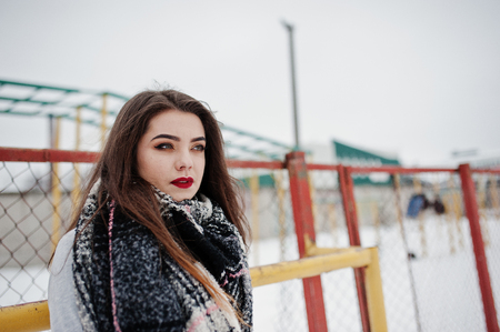 Brunette casual girl in scarf at winter on street.の写真素材
