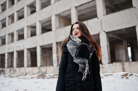 Brunette stylish casual girl in scarf against abandoned factory place.の写真素材