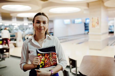 Waiter girl holding menu at cafe. People and service conceptの写真素材