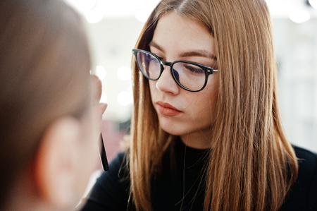 Make up artist work in her beauty visage studio salon. Woman applying by professional make up master. Beauty club concept.の写真素材