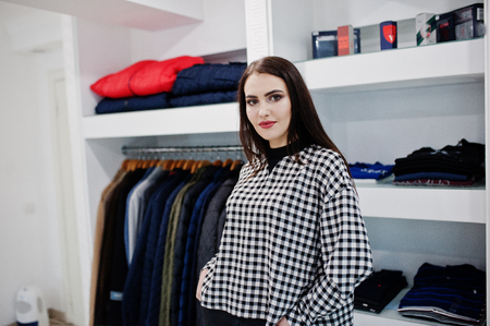 Brunette gorgeous girl in the clothing store boutique at casual clothes.の写真素材