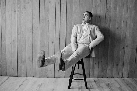 Studio portrait of man in suit against wooden background.の写真素材