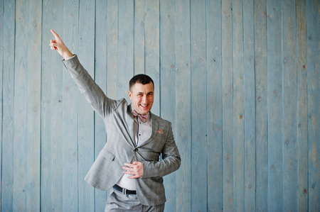 Studio portrait of man in suit against wooden background.の写真素材