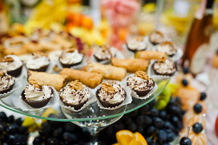 Table of wedding reception with delicious food, fruits and cakes.の写真素材