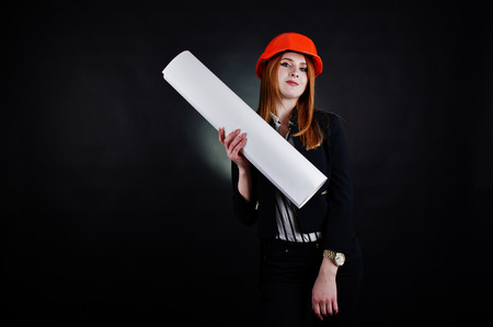 Engineer woman in orange protect helmet with construction paper projekt.の写真素材