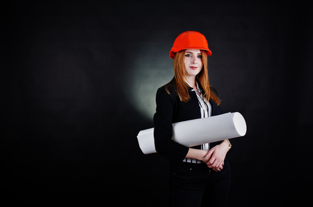 Engineer woman in orange protect helmet with construction paper projekt.の写真素材