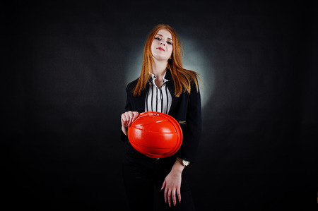 Engineer woman in orange protect helmet on studio black background.の写真素材