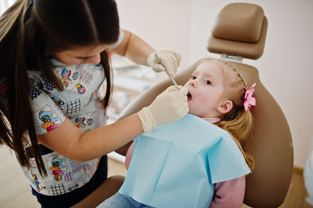 Little baby girl at dentist chair. Children dental.の写真素材