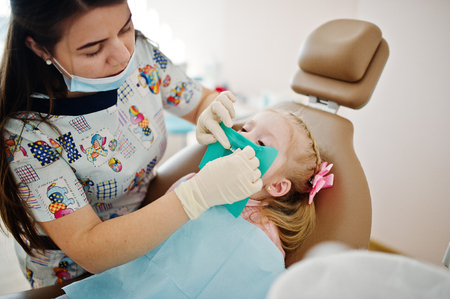 Little baby girl at dentist chair. Children dental.の写真素材