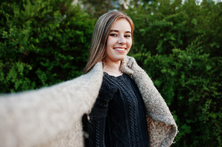 Young brunette girl on plaid having fun at evening spring day.の写真素材