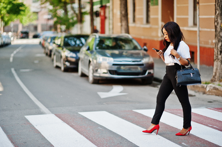 Stylish african american business woman on streets of city at pedestrian crossing.
の写真素材