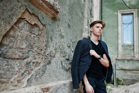 Young stylish macho boy in black jacket posed outdoor of street. Amazing model man.の写真素材