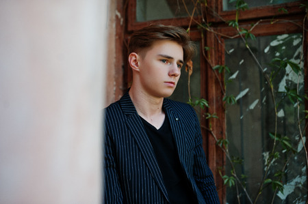 Young stylish macho boy in black jacket posed outdoor of street. Amazing model man.の写真素材