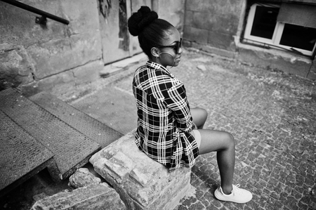 Hip hop african american girl on sunglasses and jeans shorts. Casual street fashion portrait of black woman.の写真素材