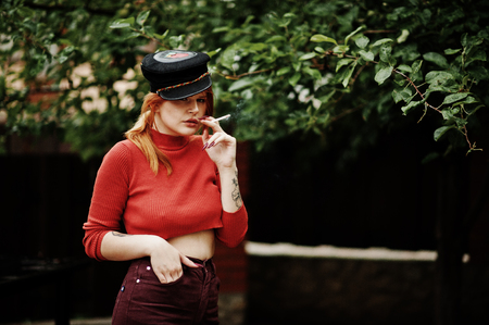 Fashion portrait of redhaired sexy girl outdoor. Model attractive seduction woman with cigarette.の写真素材