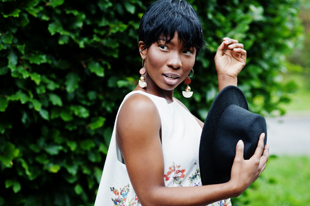 Amazing african american model woman in green pants and black hat posed with different emotions at...