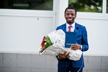 African american happy successful man at suit with diploma at graduation day.の写真素材
