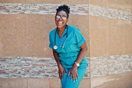African american doctor female at lab coat with stethoscope posed outdoor against clinic.の写真素材