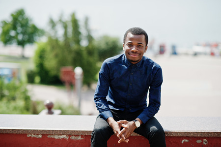 African  man posed at street of city wear on blue shirt and black pants.の写真素材