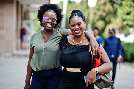 Two african american girls walking and posed at street of city.の写真素材