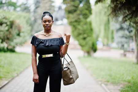 African girl posed at street of city wear on black, with handbag.の写真素材