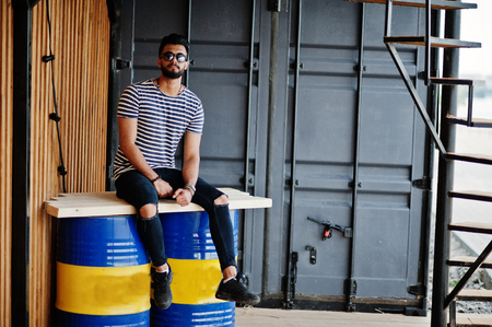Handsome tall arabian beard man model at stripped shirt posed outdoor. Fashionable arab guy at sunglasses.の写真素材