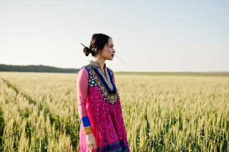 Tender indian girl in saree, with violet lips make up posed at field in sunset. Fashionable india model.の写真素材