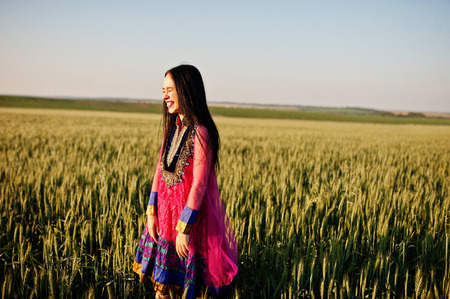Tender indian girl in saree, with violet lips make up posed at field in sunset. Fashionable india model.の写真素材