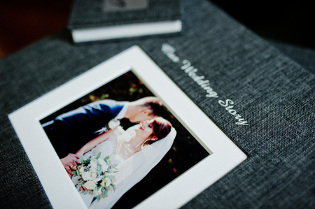 Elegant grey photo book or photo album and flash drive case on wooden stairs.の写真素材