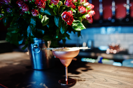 Alcoholic cocktail with fused sugar in bronze glass on bar table.の写真素材