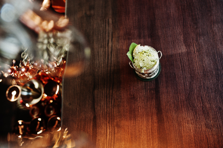 Alcoholic cocktail with ice in can glass on bar table.の写真素材