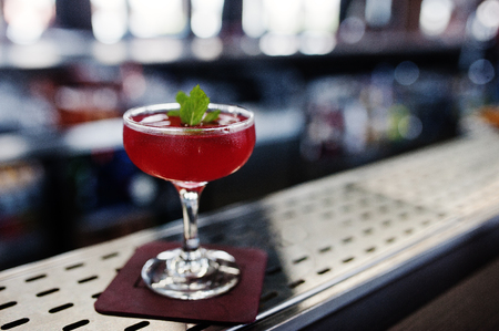 Alcoholic red cocktail with mint on bar table.の写真素材