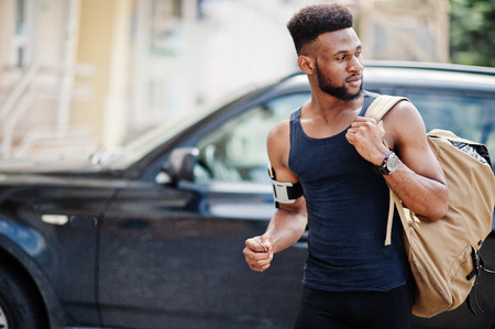 African american male athlete sport man with backpack against his black suv car before training.