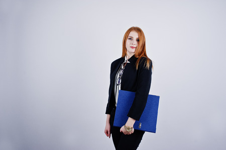 Portrait of a redheaded businesswoman wearing striped blouse and a jacket with a blue folder.の写真素材