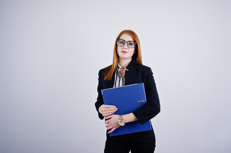 Portrait of a redheaded businesswoman wearing striped blouse and a jacket with a blue folder.の写真素材