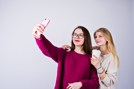Two girls in purple dresses taking selfie in the studio.の写真素材