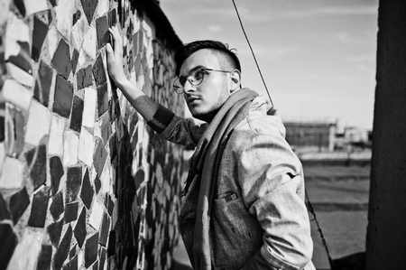 Dreamer stylish macho man in gray suit, scarf and glasses posed on the roof.の写真素材