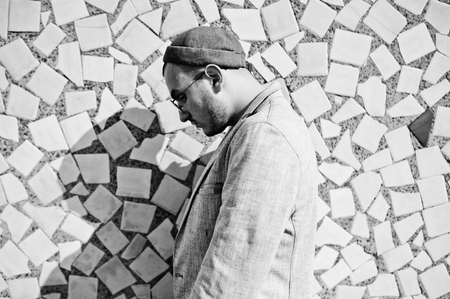 Dreamer stylish macho man in gray suit, hat and glasses posed on the roof.の写真素材