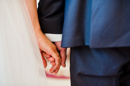 Close-up photo of wedding couple holding hands.の写真素材