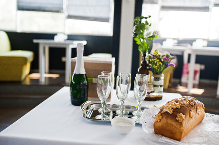 Close-up photo of a bottle of champagne, glasses, bread and salt.