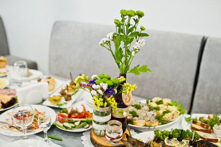Wedding table with number on it decorated with flowers and covered with huge variety of food.の写真素材