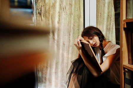 Girl with pigtails in white blouse at old library.の写真素材