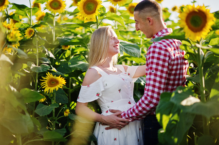 Pregnant couple in sunflowers field. Happy moments of pregnancy.の写真素材